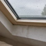 Wasserspuren an der Laibung unter einem Dachfenster