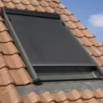 Dachfenster mit heruntergelassener Hitzeschutz-Markise an einem Sommertag