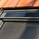 Solarmodul am oberen Rahmen eines Dachfensters mit Markise