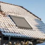 Rollladen am Dachfenster im Winter: Nutzen, Eis und Solar Geschlossener Außenrollladen am Dachfenster an einem Wintertag
