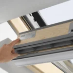 Hand zeigt auf das Typenschild eines geöffneten VELUX-Dachfensters